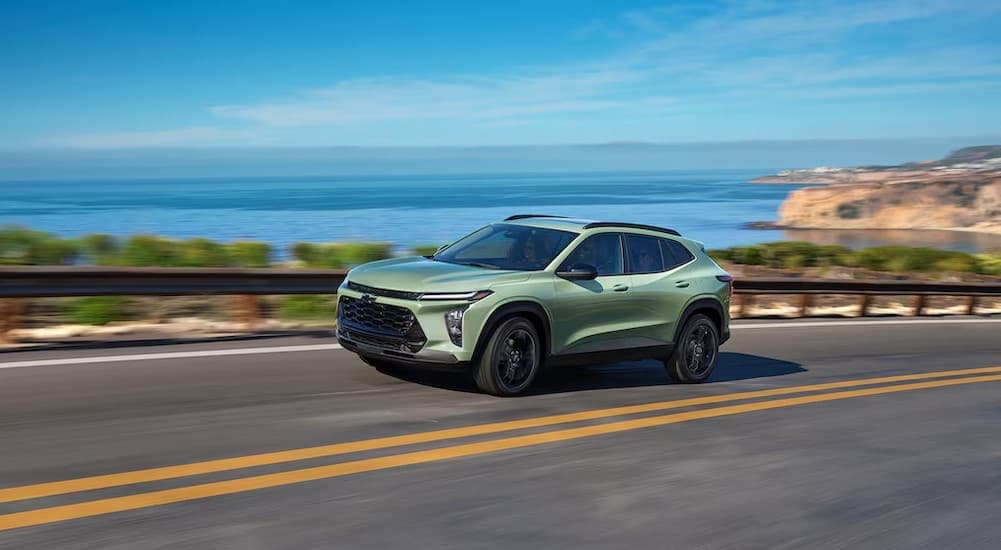 A green 2026 Chevy Trax ACTIV driving on a highway.