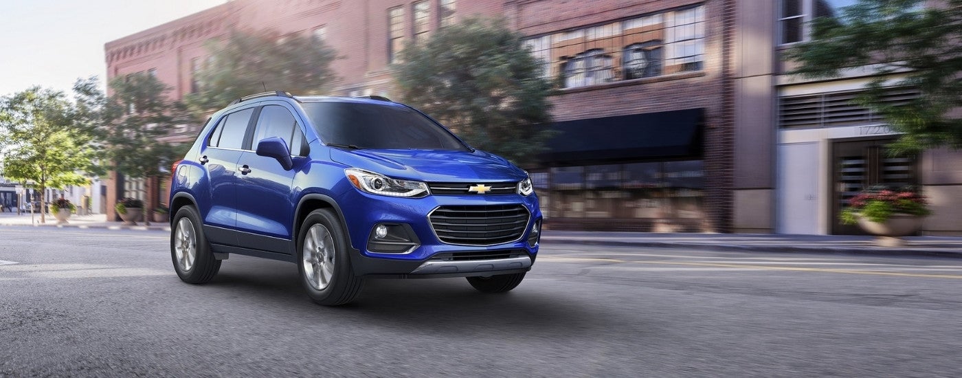 A blue 2017 Chevy Trax driving a city street.