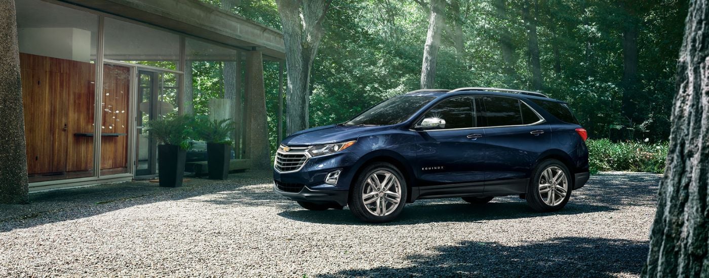 Dark blue 2020 Chevy Equinox near a modern house.