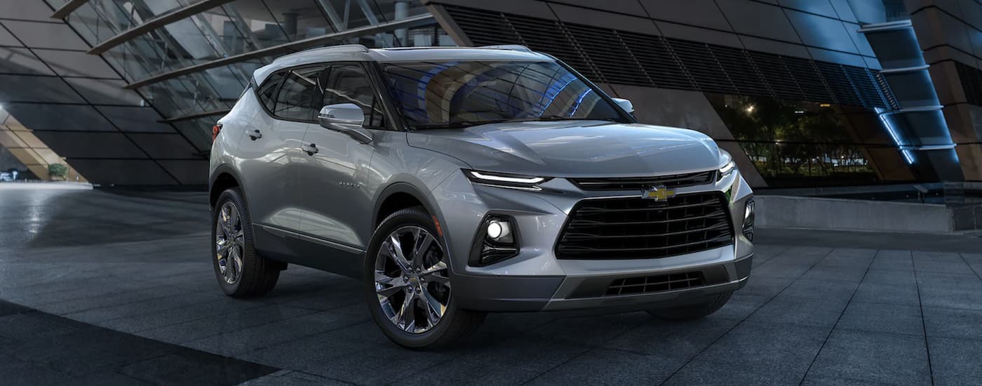 Side of a grey 2022 Chevy Blazer parked outside a building.