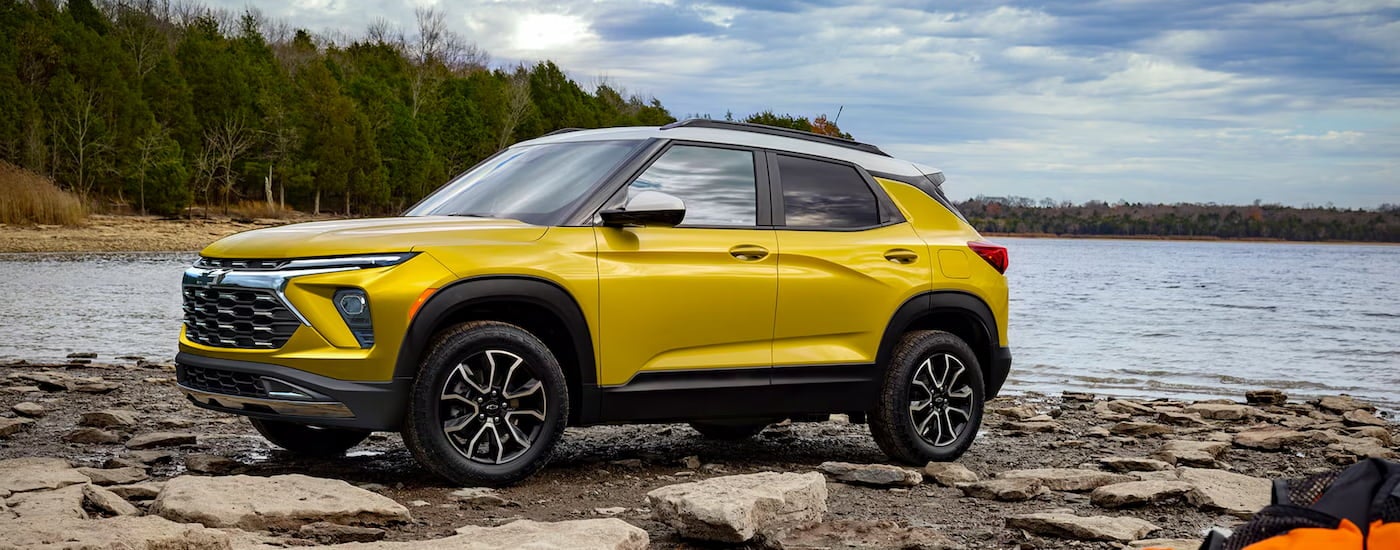 Yellow 2026 Chevy Trailblazer ACTIV parked off-road near a lake.