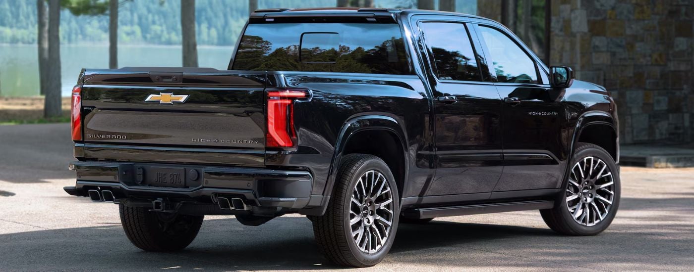 A black 2027 Silverado 1500 High Country by a lake.