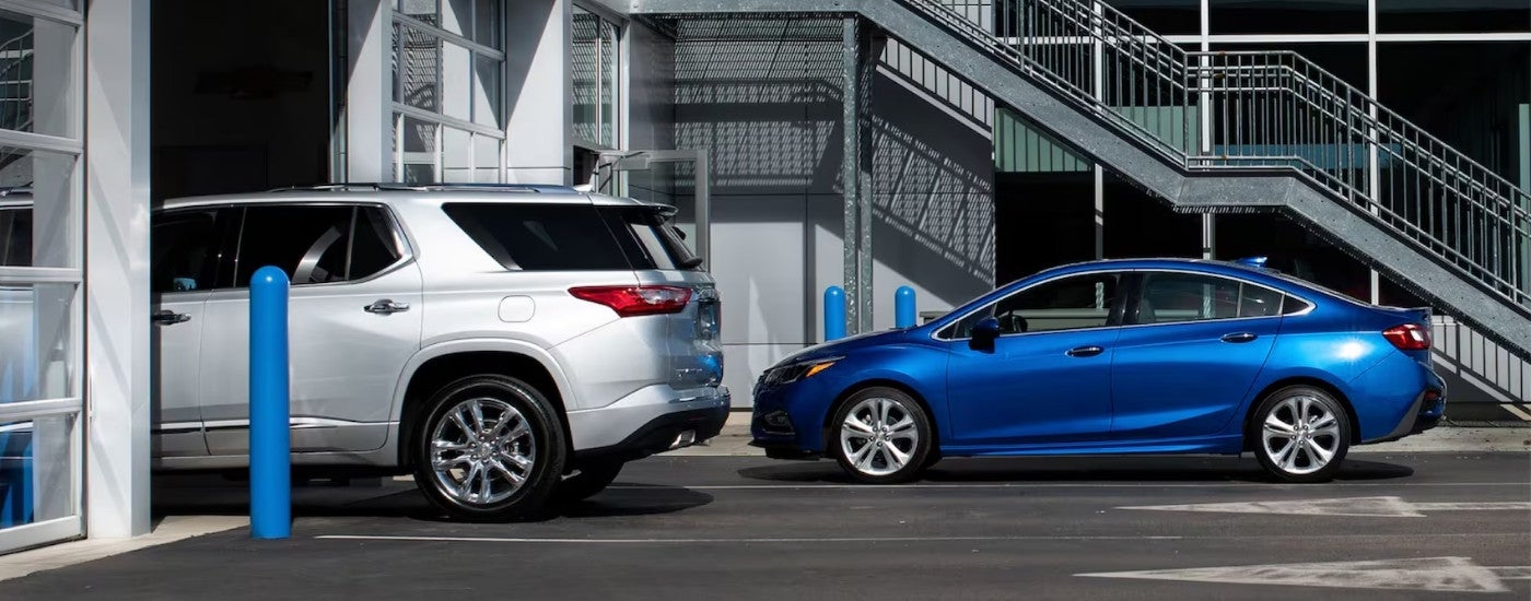 A silver 2022 Chevy Traverse and a blue 2016 Chevy Cruze are shown at a Chevrolet GMC dealer near Dickson, TN.