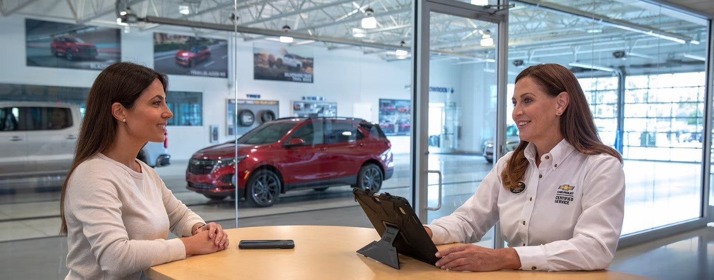 People are shown near a 2024 Chevy Equinox RS at a Chevrolet GMC dealer near Dickson, TN.