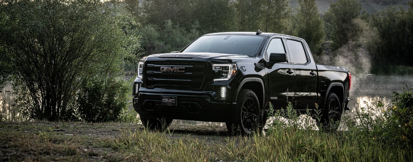 A black 2020 GMC Sierra 1500 SLE Elevation is parked near a lake.