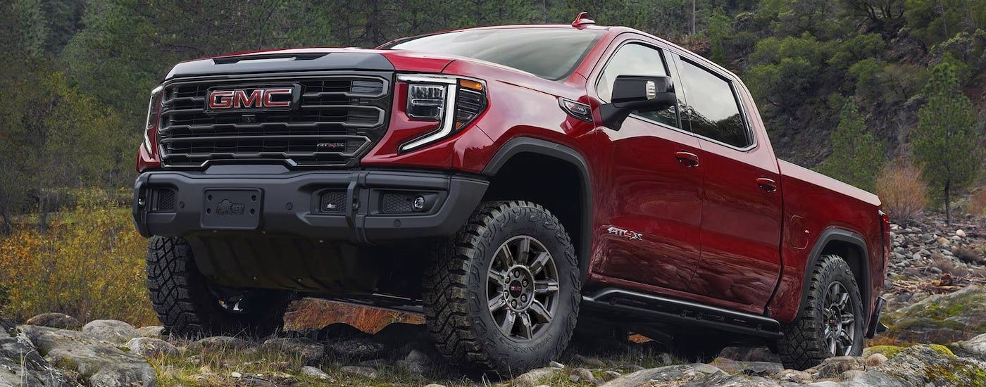 Red 2025 GMC Sierra 1500 parked off-road.