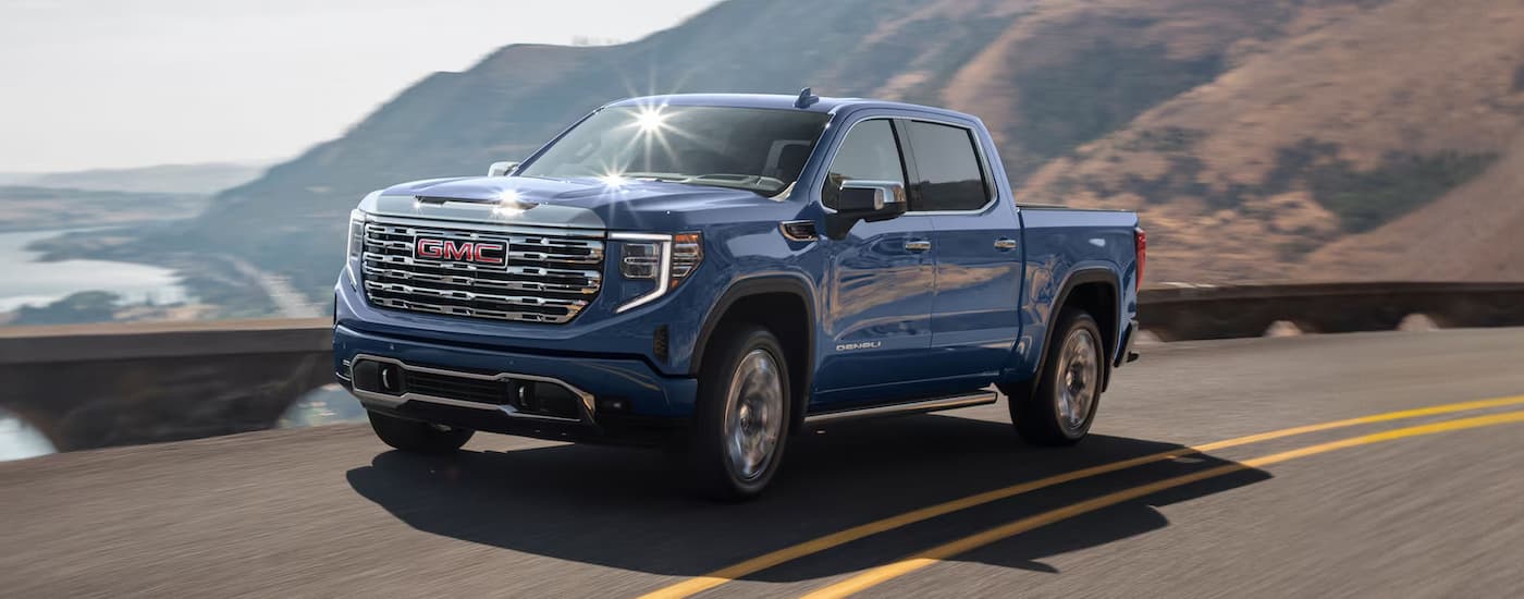Blue 2025 GMC Sierra 1500 for sale in Hopkinsville driving down an open road.