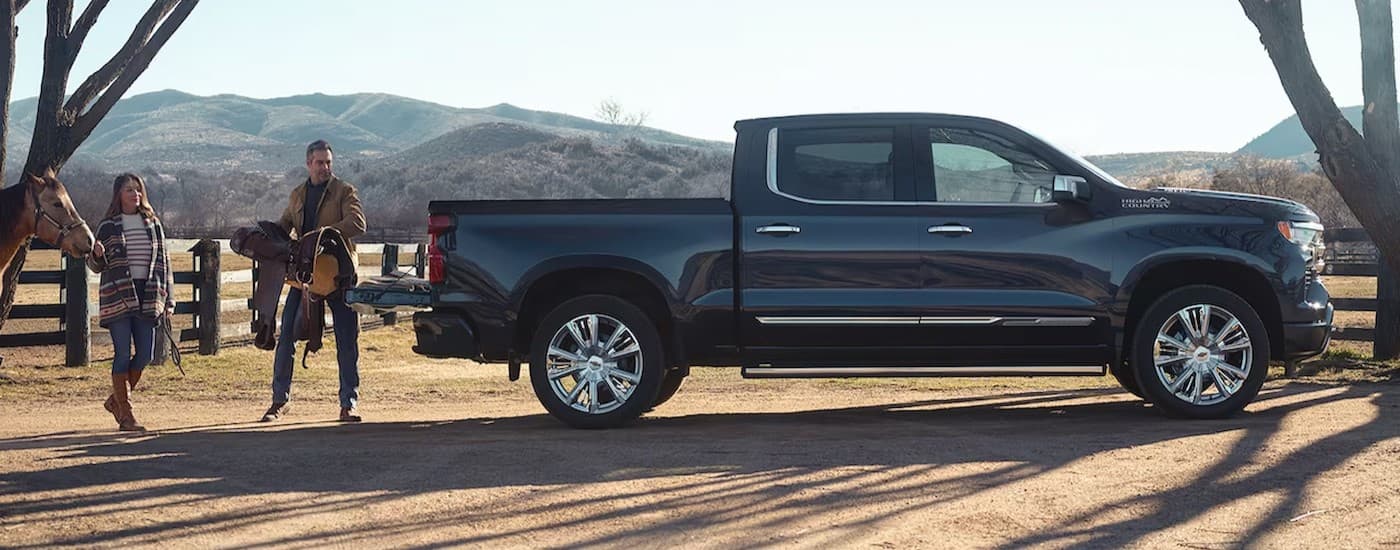 A black 2024 Chevy Silverado 1500 High Country parked on a ranch.